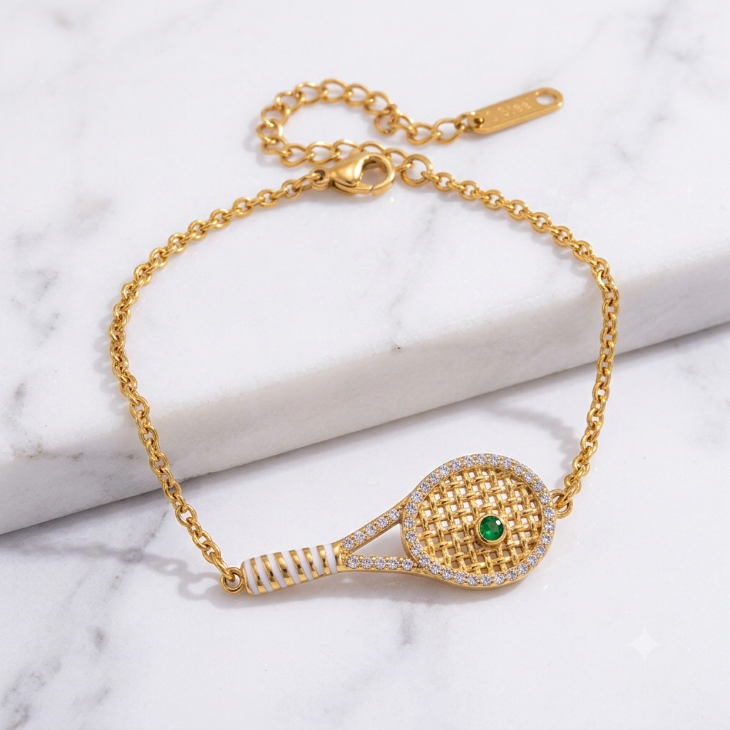 Gold bracelet with tennis racket design on a marble surface