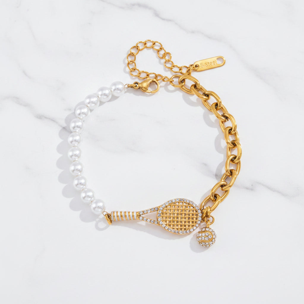 Gold tennis racket charm bracelet with pearls on a white background