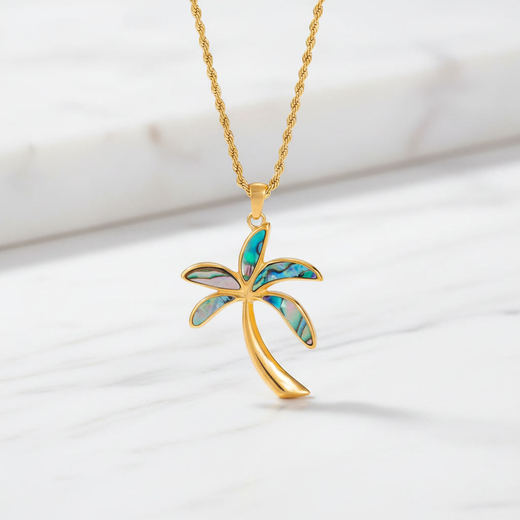 Esta Abalone gemstone necklace with a luxury gold chain displayed on a white marble surface.
